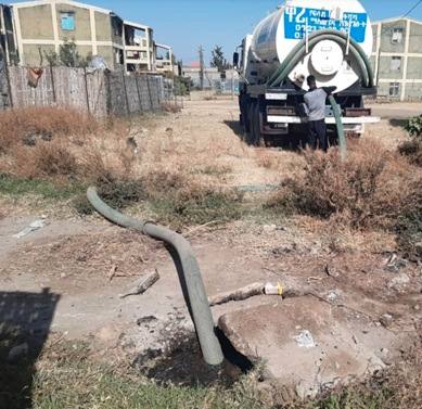 A vacuum truck emptying a condominium septic tank through a hose before the wetland was built