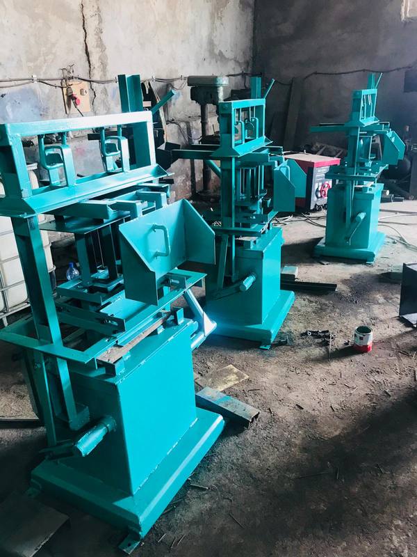 Three green steel molding machines in a fabrication workshop