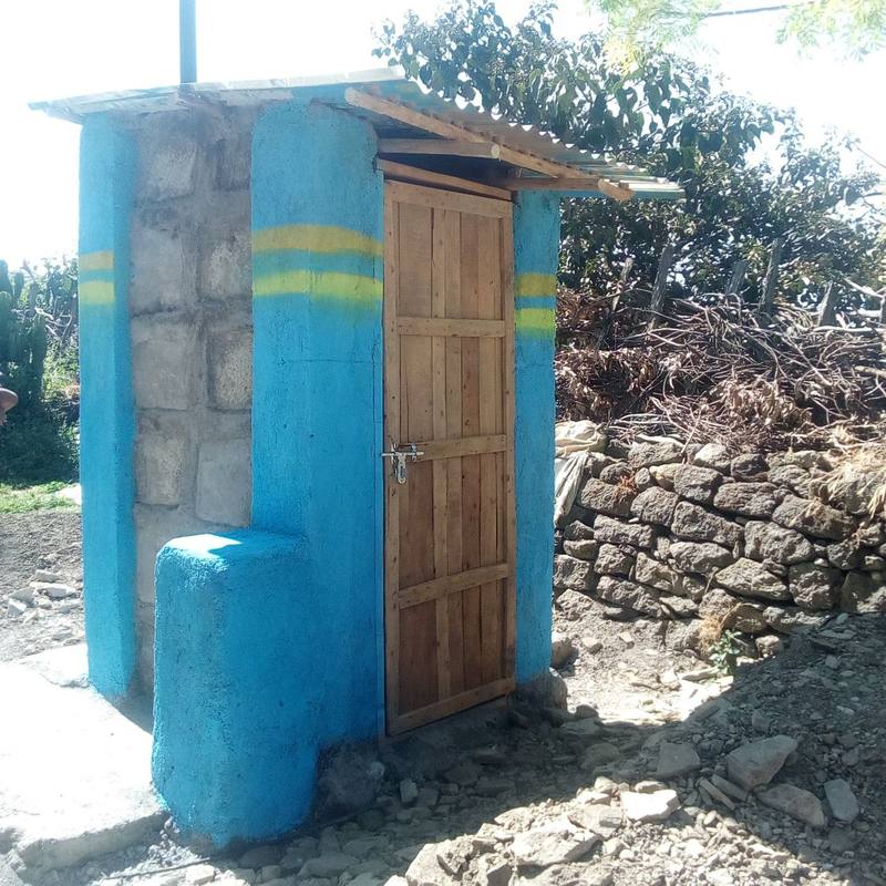 A finished Toilet-in-a-Box with a vent pipe and a hand-washing station